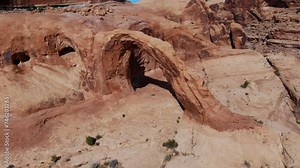 A high-flying drone shot of the Corona Arch, a massive natural sandstone arch located in a side canyon of the Colorado River, just west of Moab, Utah.
