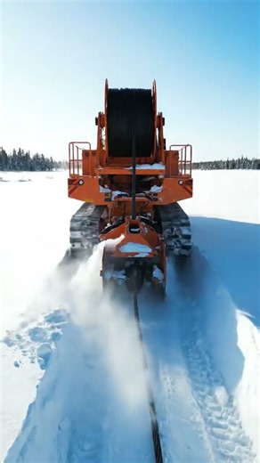 A cable-laying machine working in deep snow fields.